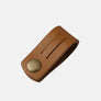 Cable wrap in tan leather, rolled and fastened with its brass press stud